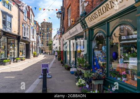 View of shops and cafes on Kirkgate and Cathedral in background, Ripon, North Yorkshire, England, United Kingdom, Europe Stock Photo