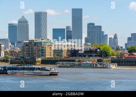 View of Canary Wharf Financial District and taxi boat from the Thames Path, London, England, United Kingdom, Europe Stock Photo