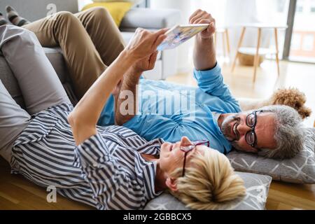 Excited mature couple having fun at home. Wife and husband spending weekend together, funny activity Stock Photo