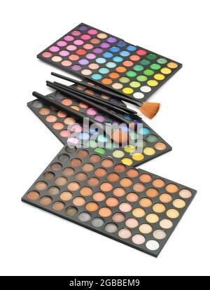 Three professional makeup shade palettes and makeup brushes isolated on white Stock Photo