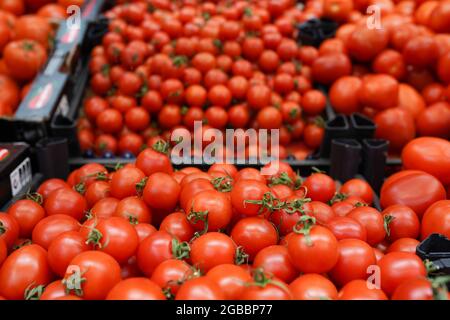 Variety of tomatoes on the farmers market, tomatoes and small cherry tomato in boxes at market stall. Top view Stock Photo