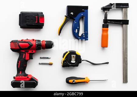 Various building instruments on white background, top view. Electric drill, ruler, clamp tools, screwdriver, flat lay Stock Photo