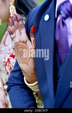 A closup shot of a young couple hugging and showing their wedding rings in india Stock Photo