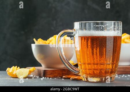 Lager beer and snacks on stone table. Cracker, chips side view Stock Photo