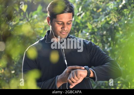 Smiling Man Using Smartwatch and Checking Physical Activity on Smartwatch Stock Photo