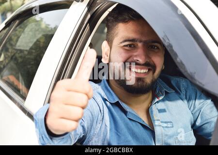 Indian Man Showing Thumbs Up from Car Stock Photo