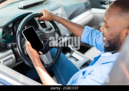 Happy black man using showing smartphone with empty screen Stock Photo