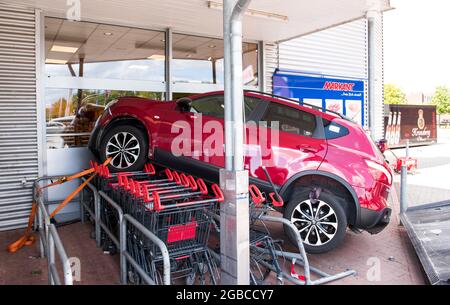 03 August 2021, Schleswig-Holstein, Bredstedt: A car is on shopping carts after a traffic accident in front of a supermarket. An elderly man lost control of his car at noon and came to a halt on shopping carts in front of the discount store, no one was injured. Photo: Daniel Bockwoldt/dpa Stock Photo