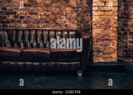 Modern classic black interior with capitone brown leather chester sofa. Stock Photo