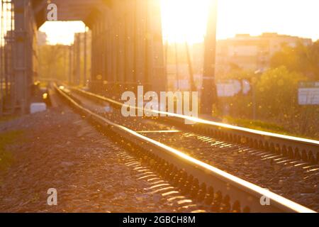 Blurred image of railway tracks, glitter of dust in the sun, railway tunnel and sunset Stock Photo