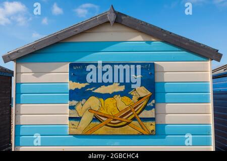 England, Hampshire, Hayling Island, Funny Painting of Fat Lady Asleep in Deck Chair on side of Colourful Beach Hut Stock Photo