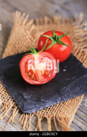 cherry tomatoes and bunch tomatoes on rustic wooden background Stock Photo