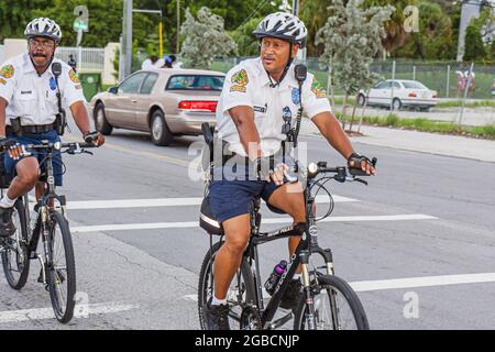 Miami Florida,police officer policemen men,bicycle riding riders bike patrol wearing safety helmet law enforcement, Stock Photo