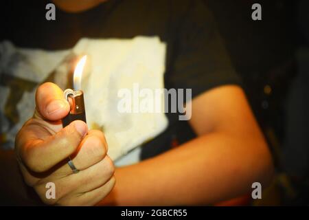 The man holding  lighter in the dark. Stock Photo