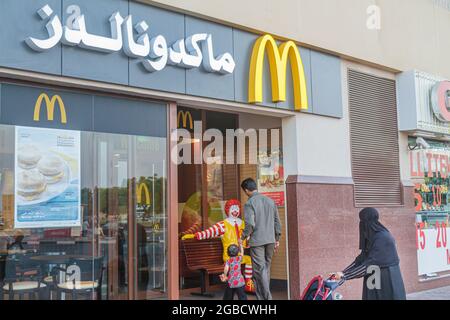 United Arab Emirates UAE Dubai,Al Souqe Al Kabeer Al Ghubaiba Road,McDonald's fast food restauran,Asian man couple boy son father family child,woman f Stock Photo