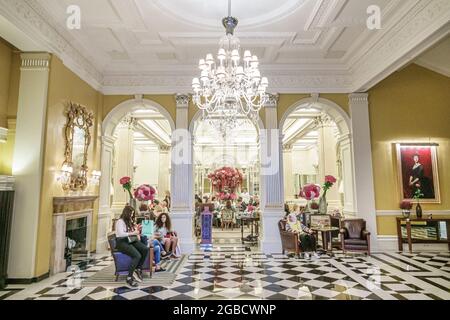 London England,UK,Mayfair Claridge's hotel 5-star luxury historic building,inside interior lobby chandelier Black white checkerboard marble floor, Stock Photo