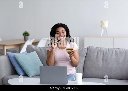 Happy young black lady enjoy easy fast secure transferring money in app Stock Photo