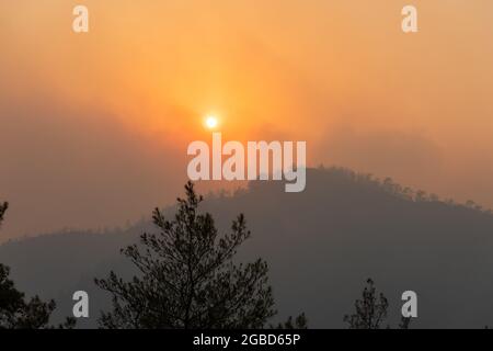 Sun shining through a cloud of smoke in Marmaris resort town of Turkey, following forest fires of July-August 2021. View on August 1, 2021. Stock Photo