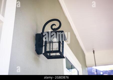 Retro black metal iron outdoor light lamp lantern hung on the exterior front entrance of a house home Stock Photo