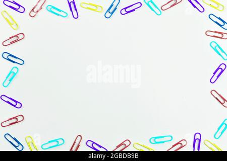 Multicolored paper clips on white background with space for text. Stock Photo