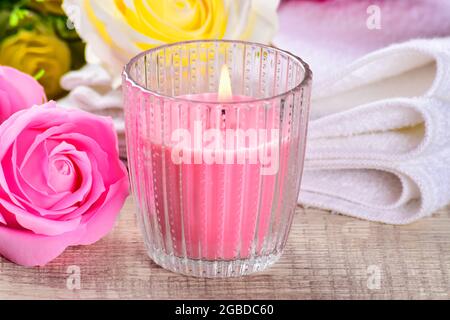 Scented candle burning on sofa table Photo taken in natural light  Scented candle with roses burning on table Stock Photo