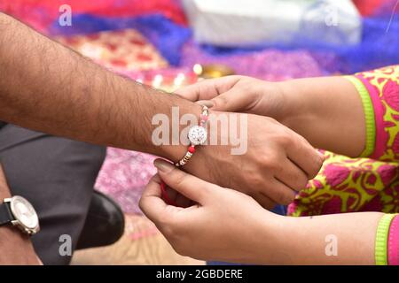 Sister Binding Rakhi On Brother Hand, Raksha Bandhan Occasion Stock Photo