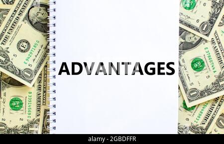 Advantages symbol. Concept word 'advantages' on white note. Beautiful background from dollar bills. Business and advantages concept, copy space. Stock Photo