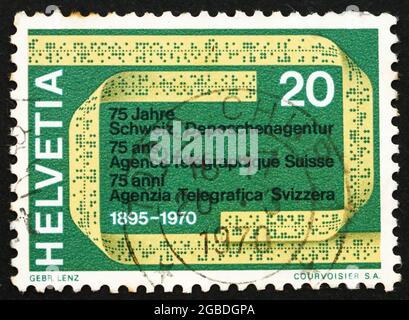 SWITZERLAND - CIRCA 1970: a stamp printed in the Switzerland shows Telex Tape, 75th Anniversary of the Swiss Telegraph Agency, circa 1970 Stock Photo