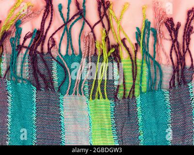 Striped knitted cotton fabric fringe texture top view. Colorful stripes knitwear background. Fashion multicolor clothes trend Handmade blog backdrop t Stock Photo