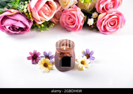 still life interior decoration brown candle with flower, colorful roses on background Stock Photo