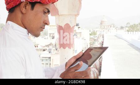 Indian man in traditional clothing using a tablet Stock Photo