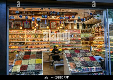 Turkey. 10th Nov, 2017. Woman wearing a hijab and track pants, sitting at a table inside a shop filled with colorful souvenirs, ceramics, spices, and other foodstuffs, located in the Arasta Bazaar in the Sultanahmet district of Istanbul, Turkey, November 10, 2017. (Photo by Smith Collection/Gado/Sipa USA) Credit: Sipa USA/Ģ����ý Live News Stock Photo