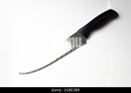 Very sharp serrated chrome metal knife with plastic handle, isolated on white background Stock Photo