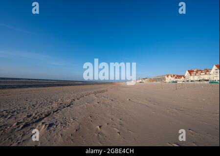 Yellow sandy beach in small Belgian town De Haan or Le Coq sur mer, luxury vacation destination, summer holidays on sunset Stock Photo