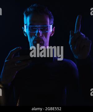 Conceptual portrait of a mysterious guy using a futuristic technology Stock Photo