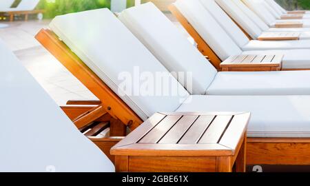 Blank white loungers in a row in luxury hotel. Sunbed for sunbathing in the inn. Stock Photo