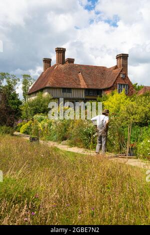 Great Dixter house and gardens, home of Christopher Lloyd, gardener tending plant border, Northiam, East Sussex, uk Stock Photo