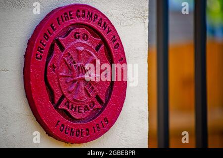 A fire department seal adorns Creole Firehouse #1 in Mobile, Alabama. The seal features a ladder, hoses, and an ax inset into a Maltese cross. Stock Photo