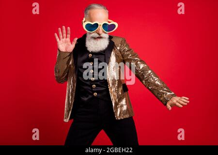 Photo of funky happy positive young man dance good mood wear funny sunglass isolated on red color background Stock Photo