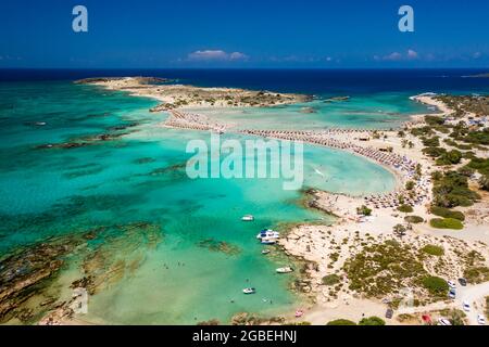 Aerial view of a beautiful but busy sandy beach and shallow lagoons surrounded by clear, blue ocean (Elafonissi, Crete,Greece) Stock Photo