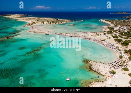 Aerial view of a beautiful but busy sandy beach and shallow lagoons surrounded by clear, blue ocean (Elafonissi, Crete,Greece) Stock Photo