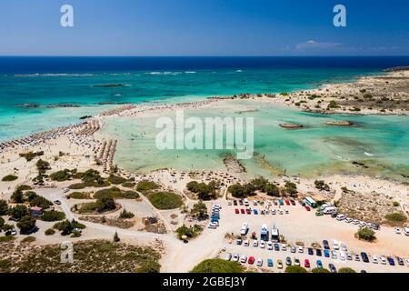 Aerial view of a beautiful but busy sandy beach and shallow lagoons surrounded by clear, blue ocean (Elafonissi, Crete,Greece) Stock Photo