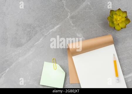 Open notepad on gray marble background. Stock Photo