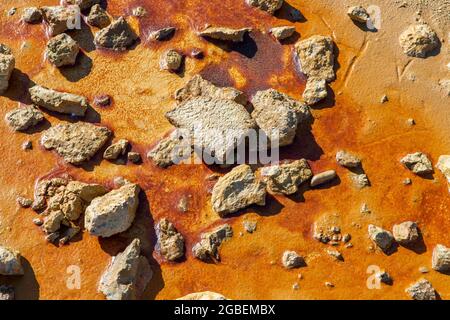 set of different stones on a reddish mud floor illuminated by the sun, concept textures or backgrounds Stock Photo