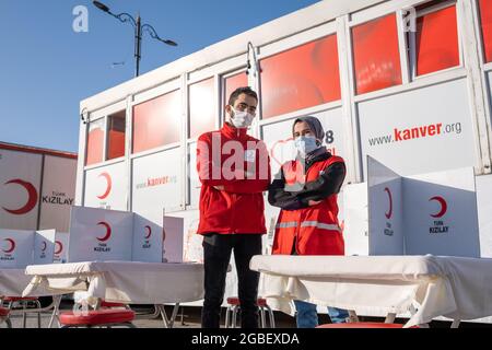 Eminonu, Istanbul, Turkey - 02.26.2021: male and female employees of Turkish Red Crescent (Turk Kizilay) in front of blood donation vehicle. Literal t Stock Photo