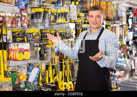 Man seller in apron having tools in hands Stock Photo