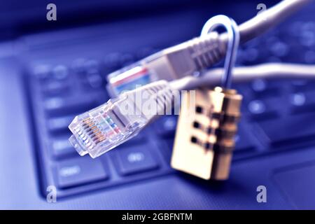 Cyber safety concept, lock and internet cable on laptop computer keyboard , Stock Photo