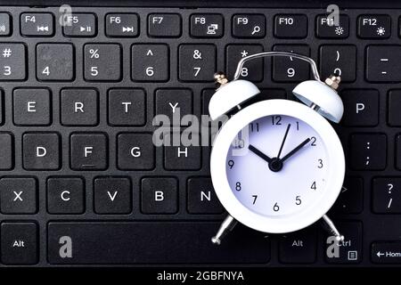 top view of clock on computer keyboard concept for time management and countdown to deadline Stock Photo