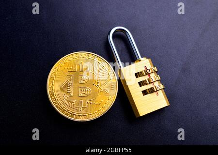 Bitcoin Cryptocurrency with lock on black texture background, bitcoin fraud prevention concept Stock Photo
