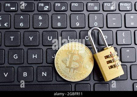 Protect bitcoin wallet concept, golden padlock and bitcoin coin on keyboard Stock Photo
